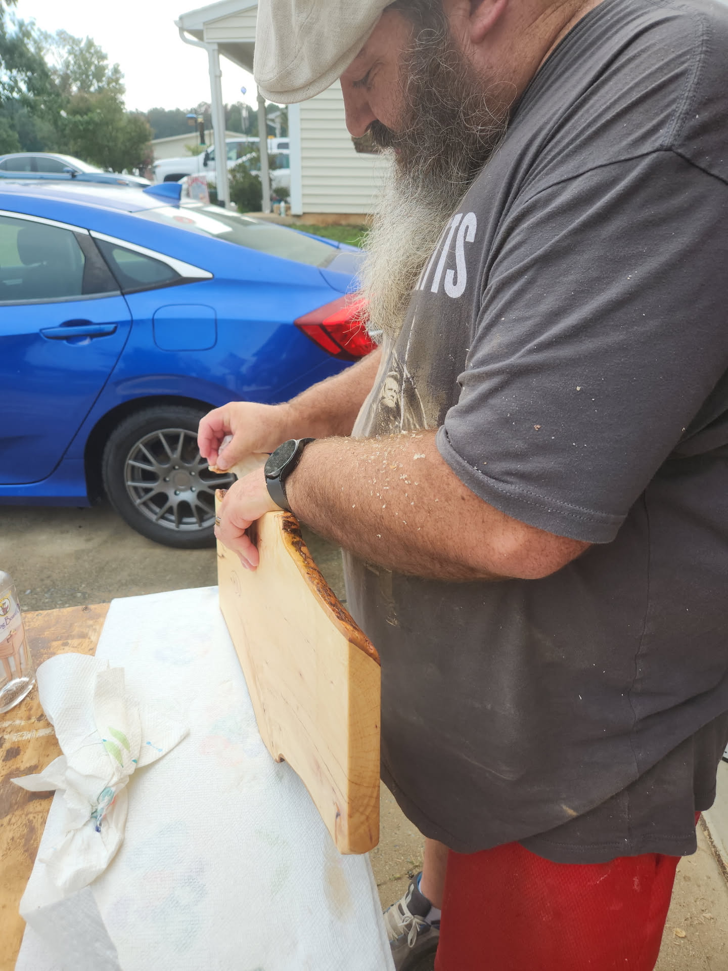 Nathan applying finish to a live-edge hardwood board